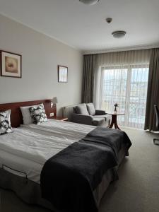 a bedroom with a large bed and a couch at Hotel Rigga in Władysławowo +34 photos