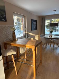 a dining room with a wooden table and a dining table and a window at Kutscherhaus in Uelzen