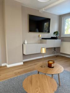 a living room with a table and a tv on the wall at Kutscherhaus in Uelzen