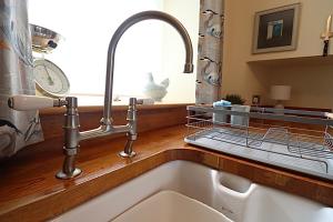 a kitchen sink with a faucet and a window at The Place in Johnshaven +25 photos