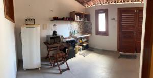a kitchen with a refrigerator and a table with a microwave at Casa Sophi in Cruz +2 photos