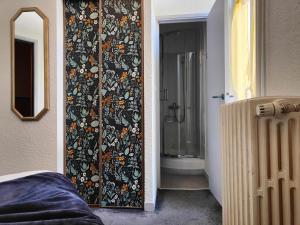a bathroom with a shower and a door with a wall at Hotel Au Val Doré in La Bourboule +136 photos