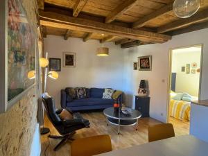 a living room with a blue couch and a table at Domaine Voilà in Génis