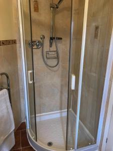 a shower with a glass door in a bathroom at Brambling Fields B&B and Cottages in Malton