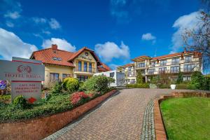 a house with a brick driveway in front of a building at Hotel Rigga in Władysławowo