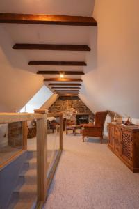 an attic room with a staircase and wooden ceilings at Sea Crest - Beachfront Escape with Whisky Snug in Cullen