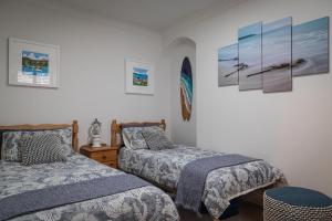 a bedroom with two beds and pictures on the wall at Sea Crest - Beachfront Escape with Whisky Snug in Cullen +32 photos