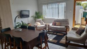 a living room with a table and chairs and a tv at The Nook in Cradock