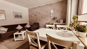 a living room with a white table and a couch at Ferienwohnungen Hoefchen in Eckfeld