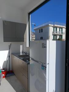 a kitchen with a white refrigerator and a window at Villa Ranucci Formia guesthouse in Formia