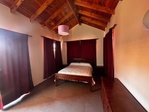 a bedroom with a bed in a room with red curtains at Alma Apart in Los Molles +31 photos