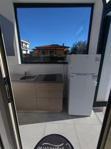a kitchen with a white refrigerator and a window at Villa Ranucci Formia guesthouse in Formia