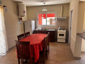 a kitchen with a red table with chairs and a refrigerator at Alma Apart in Los Molles