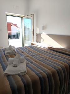 a bedroom with a large bed with towels on it at Villa Ranucci Formia guesthouse in Formia
