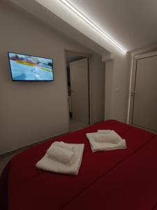 a bedroom with a red bed with two towels on it at Villa Ranucci Formia guesthouse in Formia +96 photos