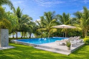 a swimming pool with lounge chairs and an umbrella at Ashansa Lagoon Resort in Tangalle