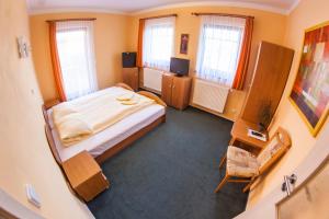 インドルジフーフ・フラデツにあるPenzion Černej ptákの小さなベッドルーム(ベッド1台、窓2つ付)が備わります。