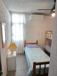 a small bedroom with a bed and a window at Departamento dos dormitorios en 3er piso por escaleras in Chajarí +14 photos