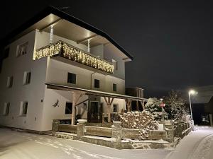 a large white building with a balcony in the snow at Tyrolyl - Ferienhaus Tirol in Inzing