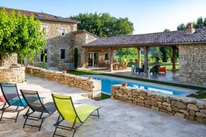 an outdoor patio with chairs and a swimming pool at Le Gîte du Taureau in Sainte-Gemme