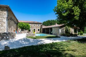 an external view of a stone house with a swimming pool at Le Gîte du Taureau in Sainte-Gemme