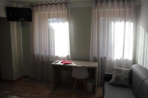 a living room with a desk and a window at Il giardino in campagna in Seren del Grappa