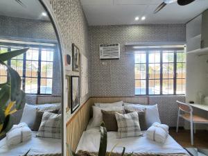a bedroom with a large bed with white pillows at Soak Screen Urban Hideaway in Iloilo City +27 photos