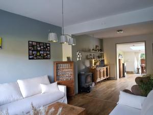 a living room with a white couch and a stove at Maison d'hôte in Grez-Doiceau