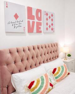 a bedroom with a pink tufted bed with two pillows at Rizz Santorini Apartment in Negombo