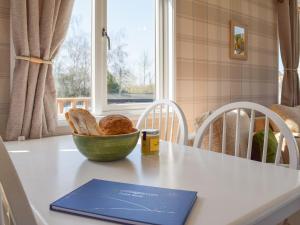 a table with a bowl of bread and a book on it at Owl Lodge - Uk49144 in Hartshorne