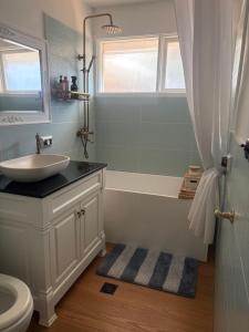 a bathroom with a sink and a tub and a toilet at Willow Place in Mornington +16 photos