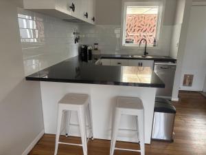 a kitchen with a counter and two stools in it at Willow Place in Mornington