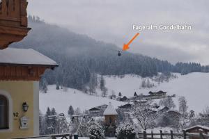 a helicopter is flying over a snow covered mountain at Baby- und Kinderbauernhof Montaning in Forstau