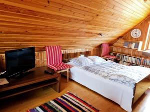 a bedroom with a bed and two chairs and a tv at Paide Homestay in Kriilevälja