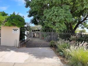 a metal gate with a sign on it in a garden at The Nook in Cradock