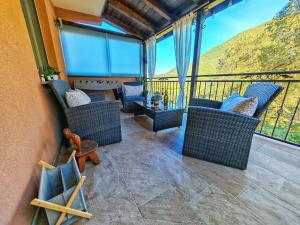 a balcony with wicker chairs and a table with a view at Cliffside Villa Vilić in Vrgorac