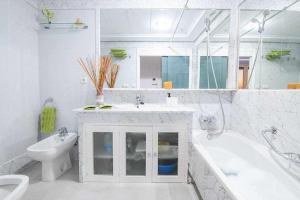 a bathroom with a sink and a tub and a toilet at Preciado apartamento con vistas frontales al mar in Cádiz +20 photos