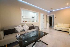 a living room with a couch and a glass table at Preciado apartamento con vistas frontales al mar in Cádiz