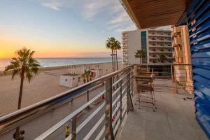 a balcony with a view of the beach and a hotel at Preciado apartamento con vistas frontales al mar in Cádiz