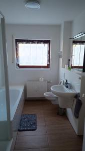 a bathroom with a sink and a tub and a toilet at Rudiferienwohnung in Büdingen +16 photos