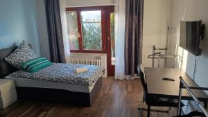 a bedroom with a bed and a desk and a window at Rudiferienwohnung in Büdingen