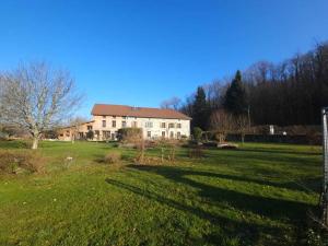 a large house in the middle of a field at La Ferme Bugiste - Maison de caractère in Belley
