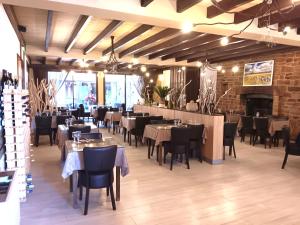 a restaurant with tables and chairs in a room at Logis Hôtel Restaurant Le Palous in Baraqueville