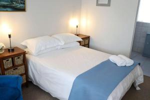 a bedroom with a large white bed with towels on it at The Nook in Cradock