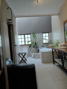 a bathroom with a tub and a table with plants at Heritage View Birding Retreat in Delareyville