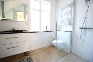 a white bathroom with a toilet and a sink at The Viking s Haven - Heart of Downtown in Reykjavík +23 photos