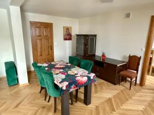 a dining room with a table and green chairs at Peter House in Nowy Targ