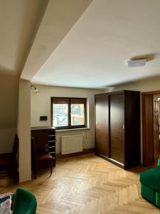 an empty living room with a desk and a window at Peter House in Nowy Targ