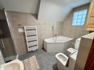 a bathroom with a tub and a toilet and a sink at Peter House in Nowy Targ