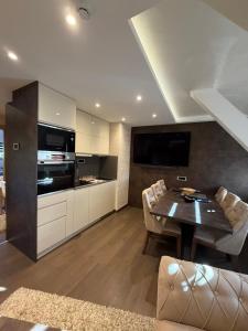 a living room with a table and a kitchen at Apartments Konaci Centar in Kopaonik